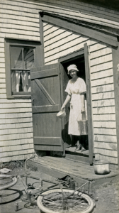 Woman at back door bicycle on ground AHM copy